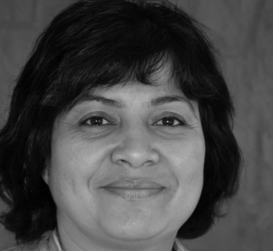 Female speaker with dark hair smiling at camera